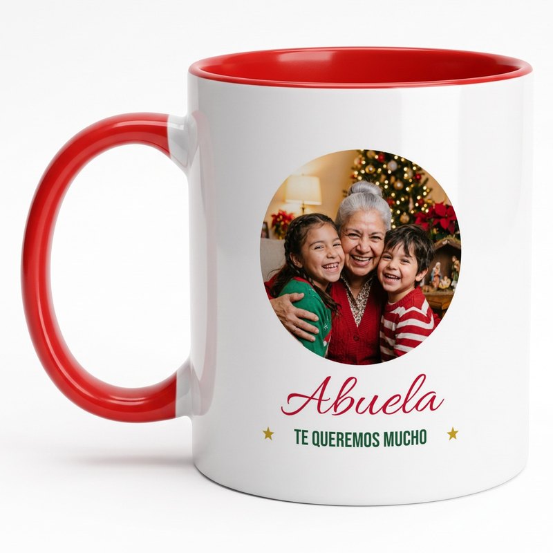 A red-rim "Abuela · Te queremos mucho" mug with an abuela and her two grandkids by a nativity scene and the Christmas tree