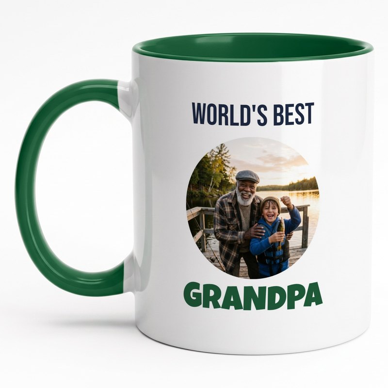 A forest-green-rim "World's Best Grandpa" mug with a grandfather and grandson holding a fish on a dock