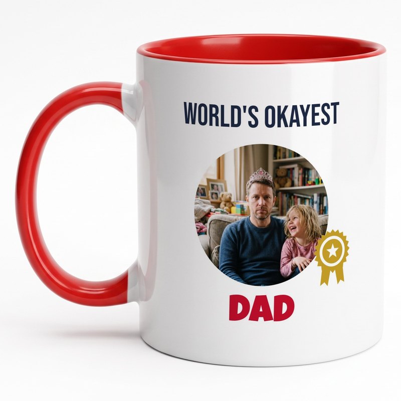 A red-rim "World's Okayest Dad" mug with a deadpan dad wearing his daughter's tiara