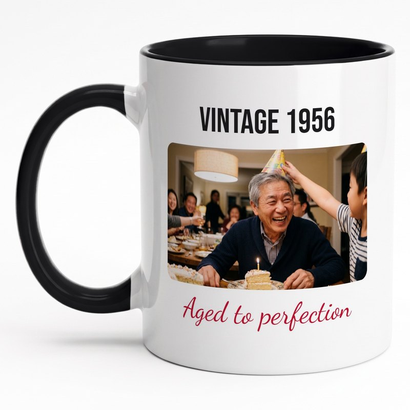 A black-rim "Vintage 1956 · Aged to perfection" mug with a laughing grandfather in a paper party hat